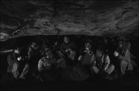  난리를 피해 굴속으로 피신해 있는 주민들. 제주 4.3 항쟁을 소재로 한 영화 <지슬>의 한 장면