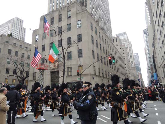 미국과 아일랜드 국기가 내걸린 뉴욕 5번가를 행진하는 사람들. 