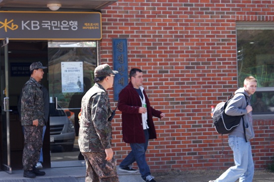 21일 부산민중연대 소속단체 회원들이 부산 남구 해군작전사령부 앞에 모여 집회를 벌인 가운데 미군들이 한국 해군의 보호를 받으며 몸을 피하고 있다. 

