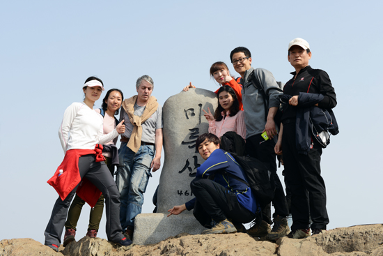 거제도 칸(KHAN)이라는 회사에서 왔다는 여행자들이 미륵산 표지석을 배경으로 기념사진을 찍었다.