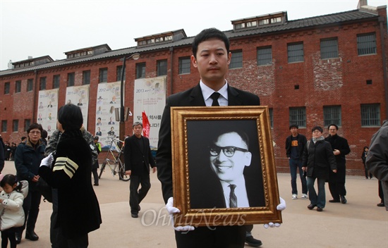 고 장준하 선생 손자인 장현욱씨가 지난 2013년 3월 30일 오전 서울 서대문구 서대문형무소 역사관에서 노제를 지낸 뒤 영정사진을 들고 형무소를 나서고 있는 모습.