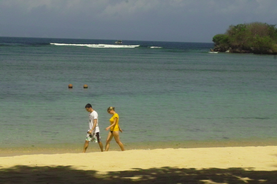 해변의 모래사장을 산책하고 있는 청춘 남녀