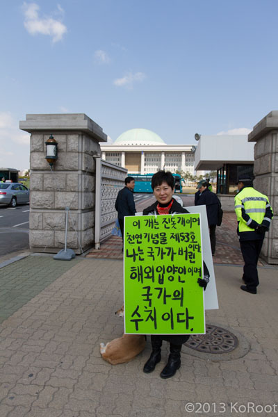  “이 개는 진돗개이며 천연기념물 제53호다. 그러나 나는 국가가 버린 해외입양인이며 국가의 수치다.“ 라고 쓴 피켓을 들고 국회에서 시위중인 해외입양인모임 대표 제인 정 트렌카
