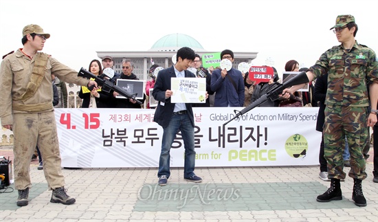  최근 남북간 긴장이 고조되고 있는 가운데 참여연대 평화군축센터 등 시민사회단체 회원들이 15일 국회 앞에서 '남북 모두 총을 내리자'며 "현재의 위기를 전쟁이 아닌 평화로, 대결이 아닌 대화로 풀자"는 내용의 퍼포먼스를 하고 있다.