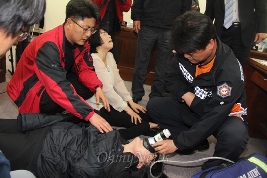 119대원이 김경숙 의원에 산소호흡기를 대고 있다.