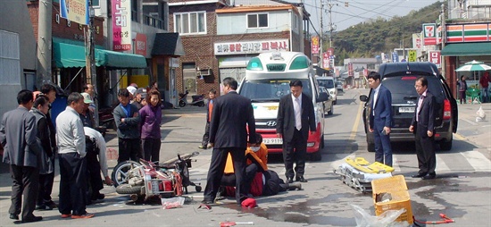 교통사고 현장 지켜보는 홍준표 지사 21일 오전 10시 20분께 홍준표 경남지사의 관용차인 카니발 승용차가 경남 창녕군 이방면 옥야사거리에서 산불감시원이 운전하던 오토바이와 부딪친 사고현장. 119구급대원들이 다친 산불감시원을 응급처치중인 가운데 홍 지사(맨 오른쪽)가 차에서 내려 사고현장을 지켜보고 있다.