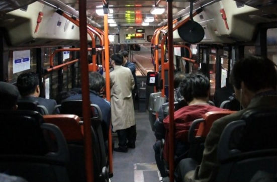 심야버스 N37번 승객들이 이어폰을 끼거나 고개를 숙인 채로 좌석에 앉아 있다.