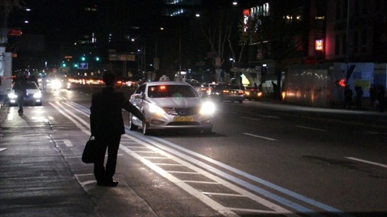 지난 19일 버스가 끝긴 시각, 종로3가에서 한 직장인이 택시를 잡기위해 팔을 내밀고 있다. 