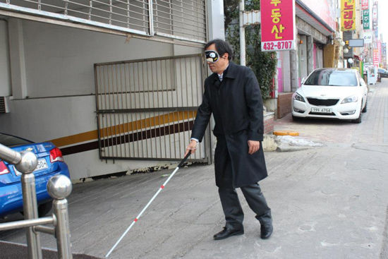  박우섭 인천남구청장이 보도에서부터 흰지팡이로 4층까지 올라가는 체험을 하고 있다.