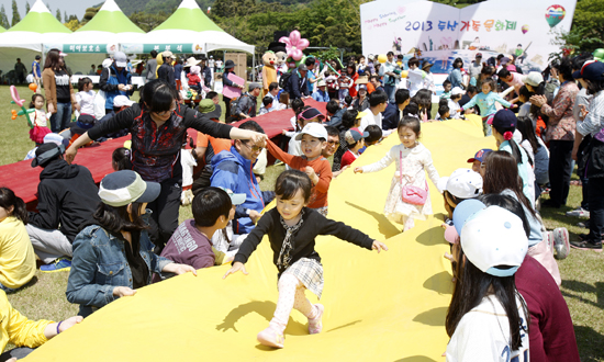 경남 창원 두산중공업 대운동장에서 열린 '2013 두산가족문화제'를 찾은 창원지역 두산 6개 계열사 임직원 자녀들과 지역 소외계층 아동들이 천으로 길게 이어진 구름다리를 달리고 있다.
