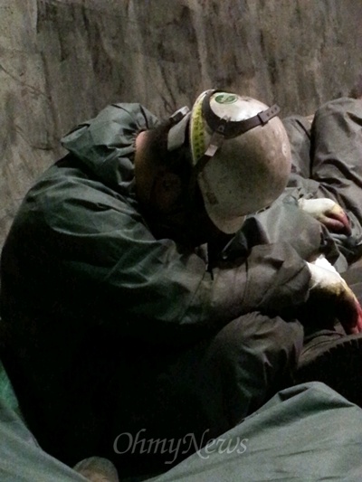 고 남정민씨 휴대전화에서 발견된 전로 보수 노동자 사진. 한 노동자가 고개를 숙이고 앉아서 쉬고 있다. 