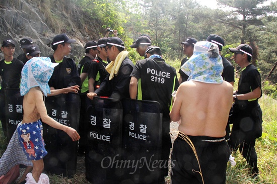  한국전력공사가 20일부터 밀양 송전탑 공사 재개에 들어간 가운데, 이날 밀양시 부북면 위양리 평밭마을 화악산에 는 127철탑 공사장 입구에서 송전탑 반대 주민인 할머니 2명이 옷을 벗고 저지하는 경찰에 맞서 실랑이를 벌이고 있다.