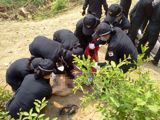 한국전력공사가 밀양 송전탑 공사를 재개한지 사흘째인 22일 오후 공사장 부근에서 한 할머니가 옷을 벗고 공사 저지 투쟁에 나서자 여성경찰들이 달라 들어 제압하고 있다.