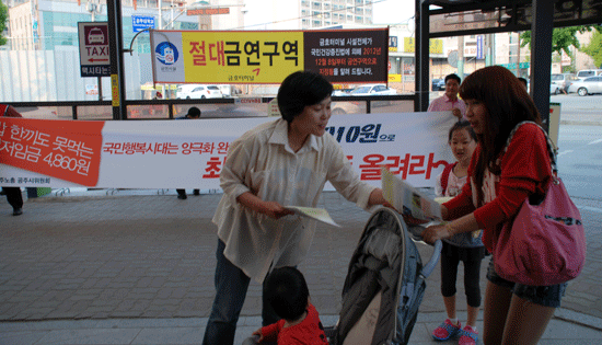 한준혜 공주민주단체협의회 집행위원장이 시민들을 상대로 최저임금에 대해 설명하며 전단을 나눠주고 있다.
