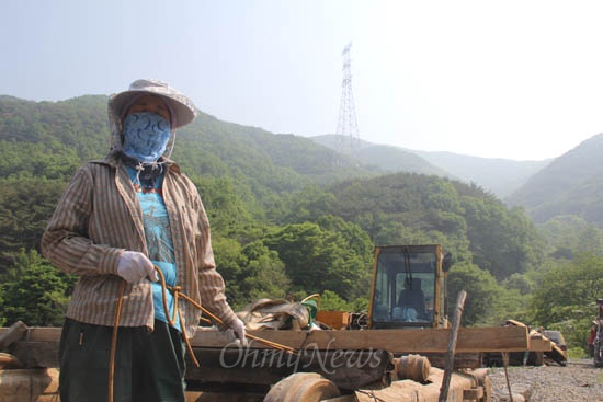  한국전력공사가 밀양 송전탑 공사를 재개한 가운데, 23일 오전 한 주민이 헬기장에 있는 장비에 몸을 묶어 옮기지 못하도록 하고 있다. 