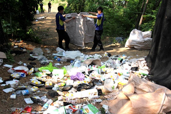 한국전력공사가 밀양 송전탑 공사를 재개해 주민들과 마찰을 빚고 있는 속에, 23일 오전 경찰들이 밀양시 부북면 평밭마을 공사현장 입구에 있는 쓰레기를 줍고 있다.