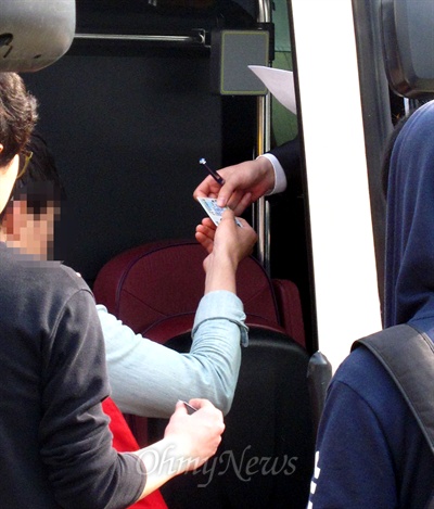 24일 오전 국정원 안보교육 참가자들이 버스에 타면서 국정원 직원에게 신분증을 보여주고 있다.