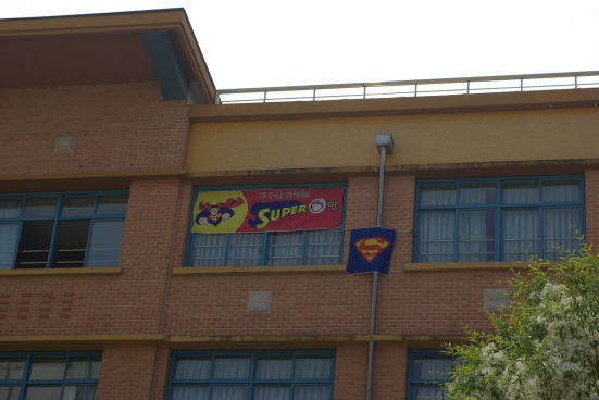 이 학교가 중학교인지 슈퍼맨 사관학교인지 순간 헷갈리게 만든 현수막. 학교 건물에 덩그러니 붙어 있으니 헷갈릴 수밖에. 지구를 지키는 슈퍼맨 양성 체육대회를 하는 건가. 하하하하하.