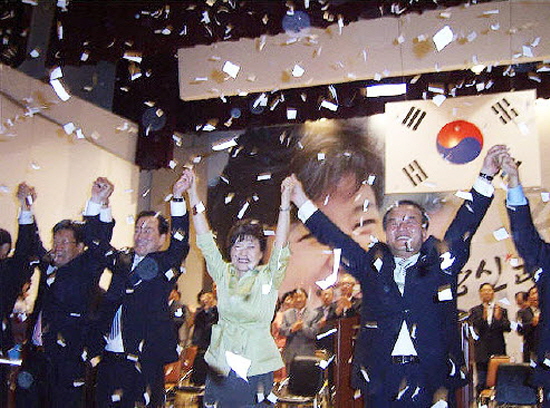 2007년 7월 9일 울산 근로자복지회관에서 박근혜 예비후보와 지역 정치인들이 손을 들어 지지자들의 환호에 답하고 있다 