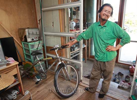 허윤석씨가 에너지 자립을 위해 손수 만든 자전거발전기를 보여주며 흐뭇한 표정을 짓고 있다.