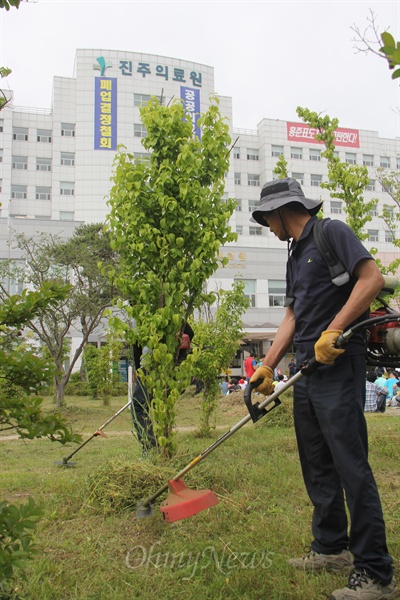  경남도가 진주의료원 폐업 발표를 한지 사흘째인 31일 오후 전국보건의료산업노동조합은 진주의료원 현관 앞에서 '폐업 철회 촉구 결의대회'를 열었다. 사진은 이날 진주농민회 회원들이 의료원을 살린다는 의미에서 정원에 난 풀을 예초기로 제거하는 작업을 벌이는 모습.