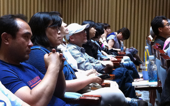 협동조합 콘서트에서 연사의 강연을 집중해서 듣는 청중의 모습