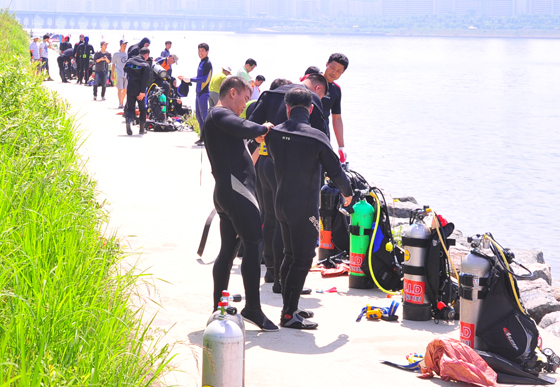 해병대 환경봉사단 다이버들이 한강 수중 오물제거를 위해 복장을 점검하고 있다.