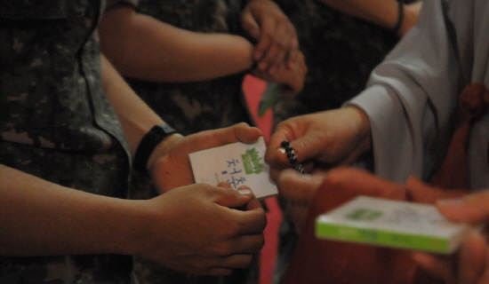 힘내라 청춘 계룡대 호국사 주지 도공스님이 장병들에게 한지민씨의 응원 편지가 담긴《힘내라 청춘》 책을 나눠주고 있다.  
