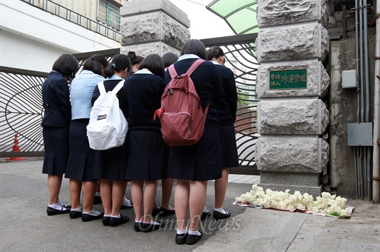 교감 추모하는 영훈국제중 학생들 입시비리 의혹으로 검찰수사가 진행중인 영훈국제중의 현직 교감이 교내에서 숨진 채 발견된 가운데 17일 오전 영훈국제중 학생들이 서울 강북구 미아삼거리역 부근 영훈국제중 교문앞에 흰 국화꽃을 놓은 뒤 묵념을 하고 있다. 영훈국제중은 사고 이후 학생들의 충격을 고려해 17~18일 이틀간 휴교조치를 취했다.