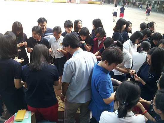홍성현 선생님께서 직접 학교에서 재배한 밀을 까먹는 이벤트 진행 모습. 아나바다 운동 중 다양한 이벤트를 진행하여 학생들의 흥미를 높인다.