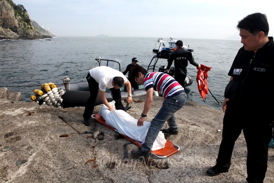 부산해양경찰서는 20일 오후 이기대공원 둘레길 해상 갯바위에서 실종 여대생인 김아무개씨의 시신을 발견했다고 밝혔다. 사진은 부산해경이 시신을 수습하고 있는 모습.