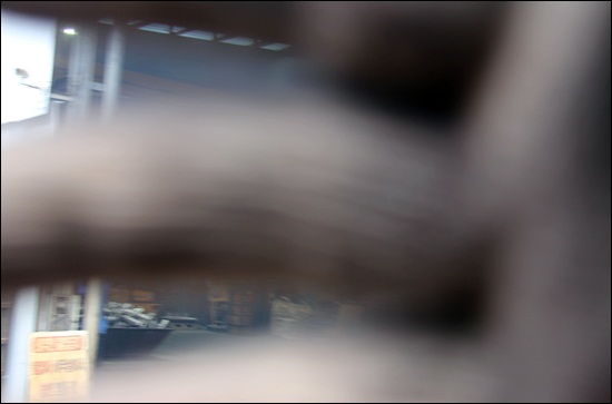 다산주물산업단지내 한 작업장 관리자가 연기가 새나오는 사업장 모습을 찍으려 하자 카메라 렌즈를 가로막고 있다.   
