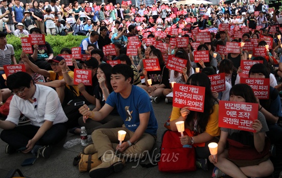 지난달 21일 오후 서울 종로구 광화문 KT 앞에서 열린 국정원 규탄 대학생 촛불문화제에 참석한 학생과 시민들이 국정원 대선 개입에 대한 국정조사 실시와 박근혜 대통령의 입장 표명을 촉구하고 있다.
