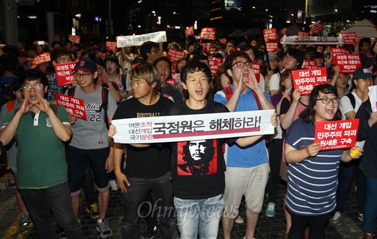 학생과 시민들이 22일 오후 서울 종로구 청계광장에서 '반값등록금 여론조작과 대선개입 국정원 규탄 촛불집회'를 마친 뒤 거리행진을 벌이다가 경찰에게 저지되자, 평화행진 보장을 요구하며 구호를 외치고 있다.