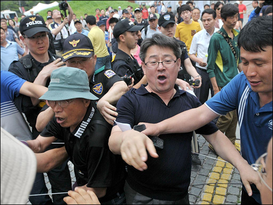 22일 오후 서울 청계광장에서 개최된 '국정원 대선개입 규탄 촛불문화제'에 어버이연합 소속 회원이 난입해 참가자들에게 욕설을 퍼붓자 경찰들이 이들을 제지하고 있다.
