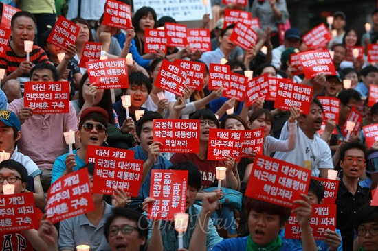  '국정원 선거개입 규탄 촛불문화제'가 23일 오후 서울 청계광장 부근 파이낸스빌딩앞에서 21세기 한국대학생연합 주최로 열린 가운데, 참석한 학생과 시민들이 '박근혜 대통령 책임져라' '민주주의 파괴 원세훈(전 국정원장) 구속' 등이 적힌 손피켓을 들고 있다.