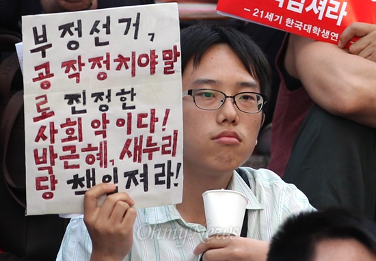 24일 오후 서울 중구 파이낸스센터 앞에서 열린 '반값등록금 여론조작과 대선개입 국정원 규탄 촛불집회'에서 한 학생이 국정원 대선 개입에 대한 박근혜 대통령의 입장 표명을 촉구하며 피켓을 들어보고 있다.