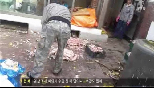 JTV 8시 뉴스 화면(5월 20일 치). 사진은 전북장애우권익문제연구소가 운영하는 시설에 거주하는 장애인이 개 사육장에서 일을 하는 장면이다.