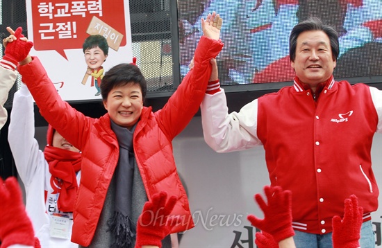 박근혜 당시 새누리당 대선후보가 지난해 11월 30일 오전 부산 사상구 서부버스터미널 유세에서 김무성 당시 총괄선대본부장과 함께 유권자들을 향해 손을 들어 인사하고 있다.