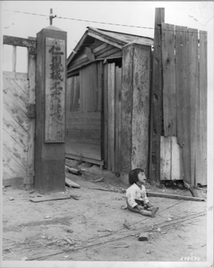 한 소녀가 사람들이 피난을 떠난 텅 빈 도시 길바닥에서 울고 있다(인천, 1950. 9. 16).
