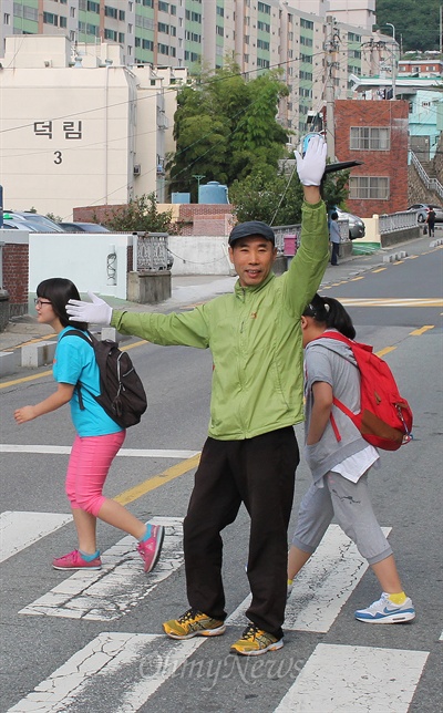 27일 부산 수정동 산복도로에서 김명섭씨가 초등학생들의 등교시간에 맞춰 횡단보도에서 통학지도를 하고있다. 
