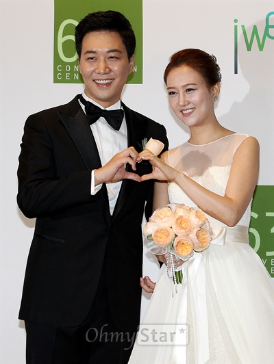  가수 장윤정(오른쪽)과 아나운서 도경완이 28일 오전 서울 여의도 63빌딩에서 결혼식에 앞서 가진 기자회견에서 하트를 만들어 보이고 있다.