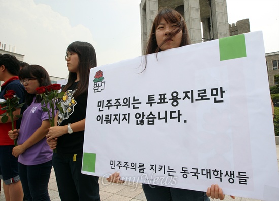 동국대 시국선언, '민주주의는 투표용지로만 이뤄지지 않는다' 동국대학교 학생들이 28일 오후 서울 중구 동국대 불상 앞에서 열린 국정원 불법 선거개입 사태 시국선언 기자회견에 참석해 국정원의 국기문란 행위를 규탄하며 빨간 장미와 피켓을 들어보이고 있다.