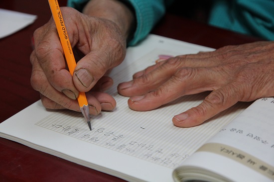 정성껏 한 자 한 자  글씨를 쓰시는 할머니의 손