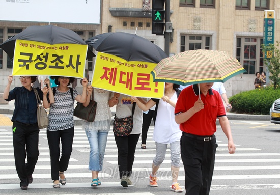 "국정조사 제대로" "책임자 처벌" "국정원 개혁"이 적힌 현수막을 우산에 붙인 참석자들이 광화문네거리 횡단보도를 돌며 홍보활동을 벌이고 있다.