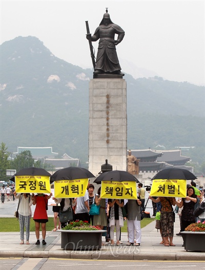 청와대가 멀리 보이는 광화문 광장 이순신동상앞에 서 있는 기자회견 참석자들.