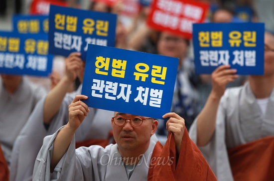 1일 오후 서울 종로 보신각앞에서 열린 '국정원의 헌법유린 규탄 시국법회'에서 참석자들이 "헙법 유린 관련자 처벌" "국정원 해체 대통령 참회" 등의 구호가 적힌 손피켓을 들고 있다.