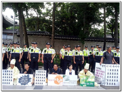 상복을 입은 문기주 한상균 전 지부장 시민들이 연대 행동 중이다.