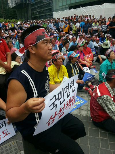 집회에 참가한 한 피해주민이 피켓을 들고 삼성의 책임을 촉구하고 있다.
