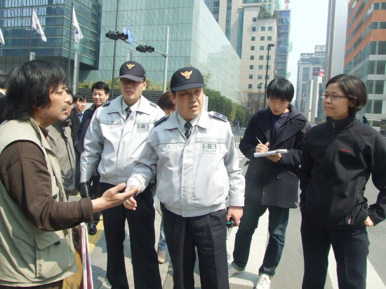 고 김주현씨 사망 80일째이던 2011년 4월 1일, 김성환 삼성일반노조 위원장(왼쪽)이 경찰, 기자 등과 이야기를 나누고 있다. 경찰은 당시 미신고 집회를 이유로 해산명령이나 진압 등을 하지 않았다. 